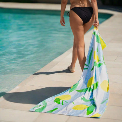 A girl dragging a Quick Dry, Sand Free, Light Weight, Compact and Ecofriendly Microfiber Beach Towel from La Toalla on the sand
